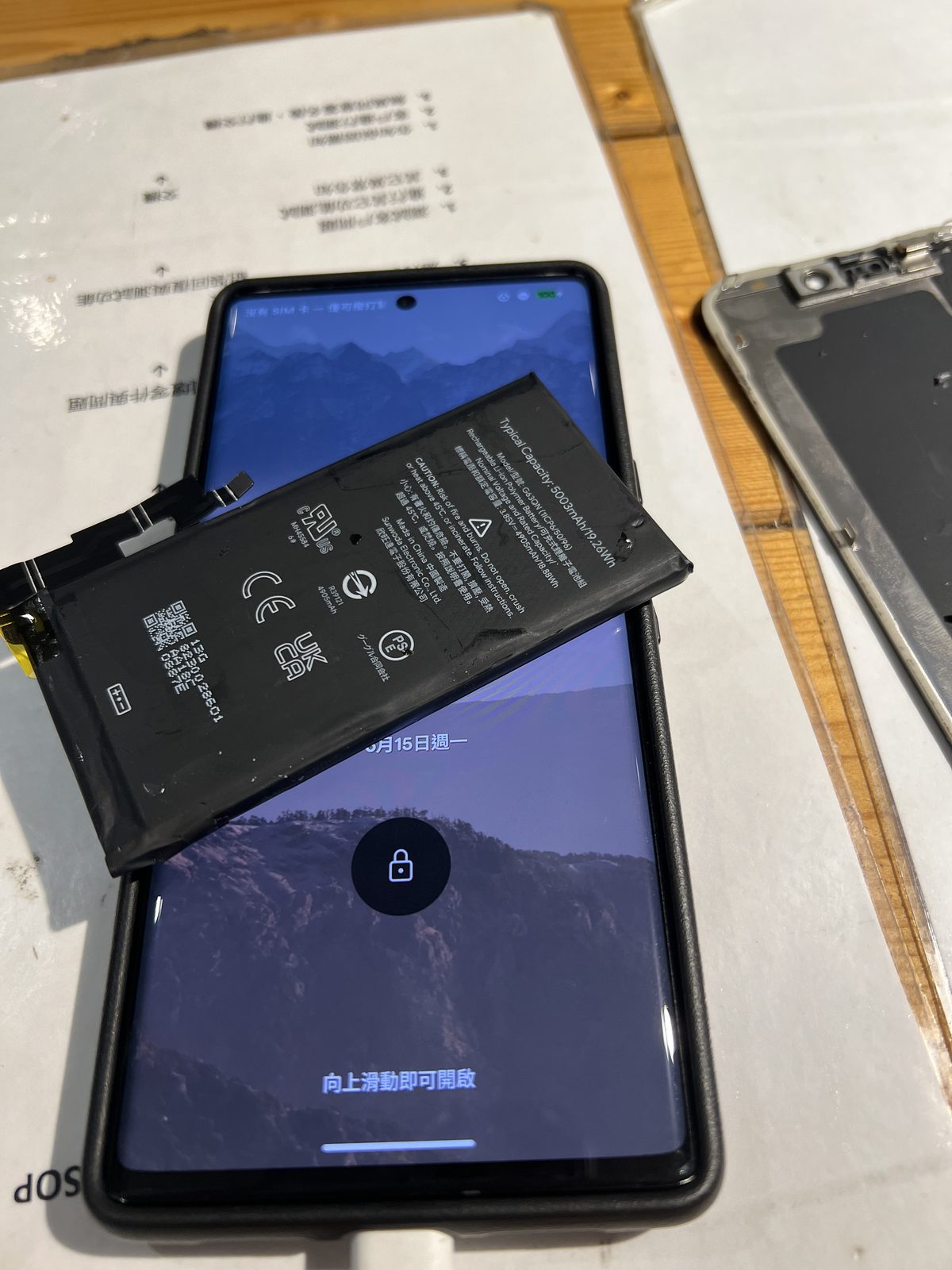 Google Pixel 6 Pro 更換電池，拆下的舊電池放在已正常開機的手機上