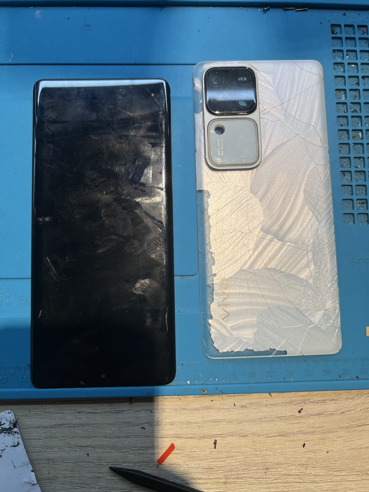 從 vivo V30 拆下的舊螢幕總成與整片龜裂的背蓋玻璃